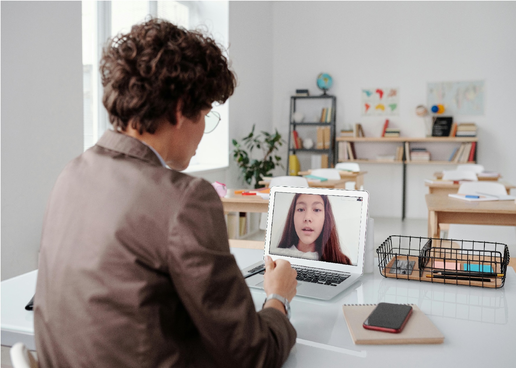 A young man with his back to the camera on a video call with a young lady