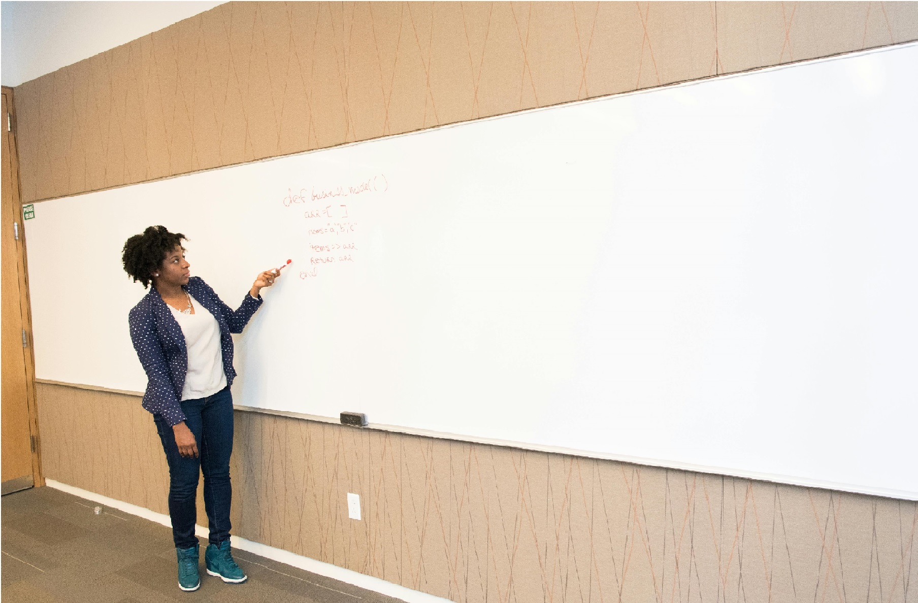 A woman teaching in front of a whiteboard