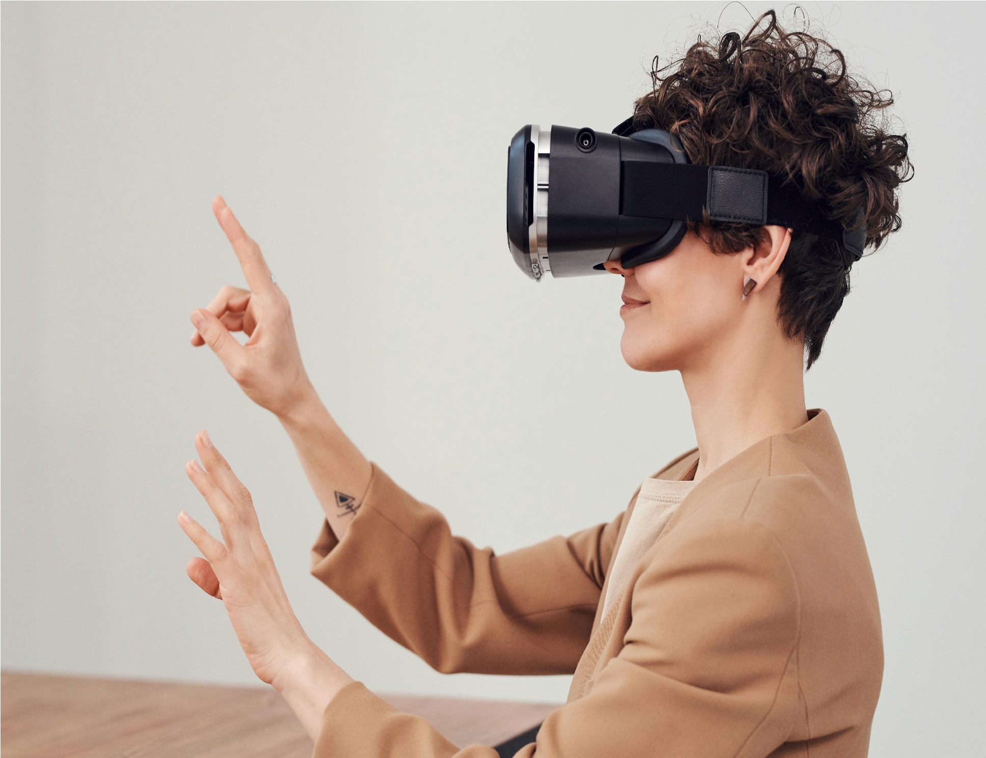 Someone wearing a virtual reality headset while holding their hands in the air
