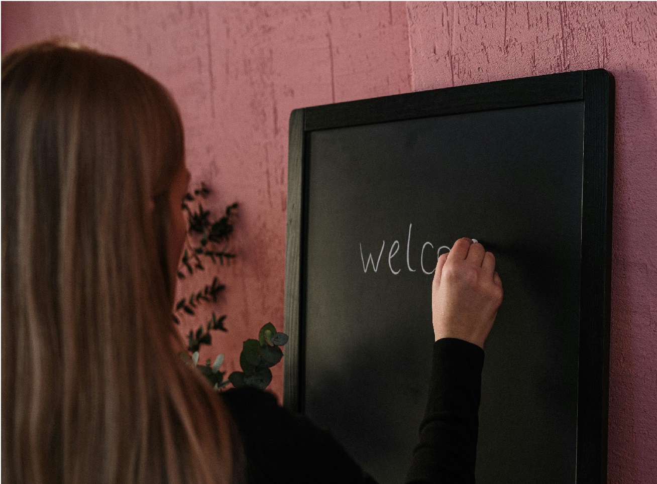 Woman Writing Welcome on Blackboard